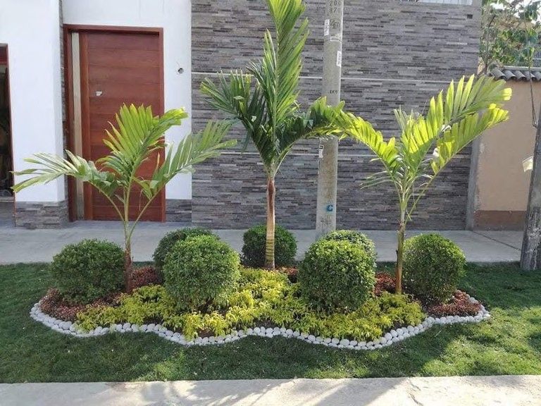 Fachada con palmeras y topiarios recortados